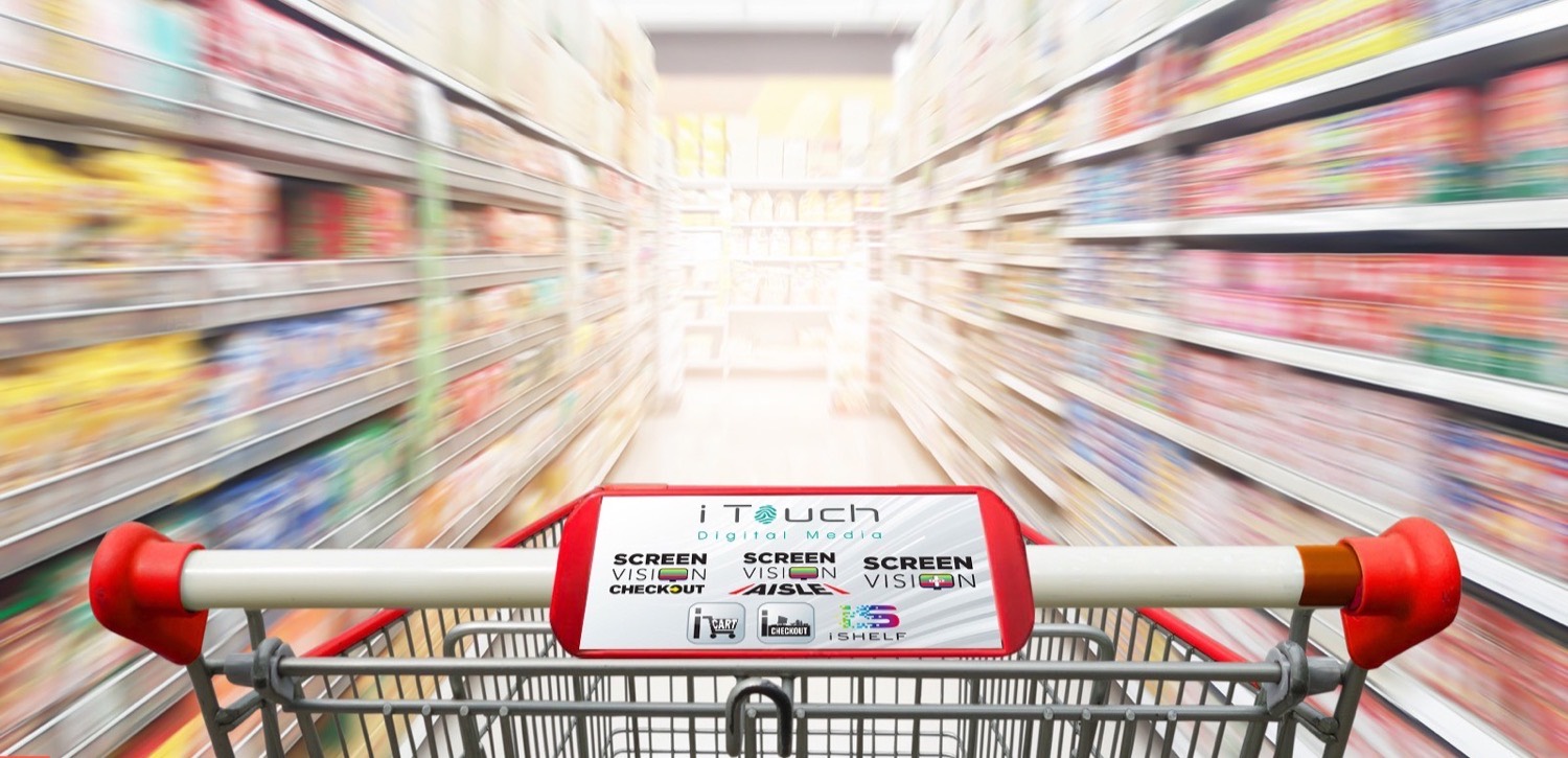 View down a supermarket aisle from behind a shopping cart branded with the iTouch Digital Media panel, showing the Screen Vision Checkout, Screen Vision Aisle, Screen Vision Plus, iCart and iShelf product marks.